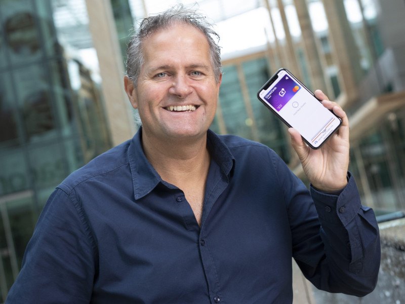 Headshot of CleverCards CEO and founder Kealan Lennon holding a smartphone.