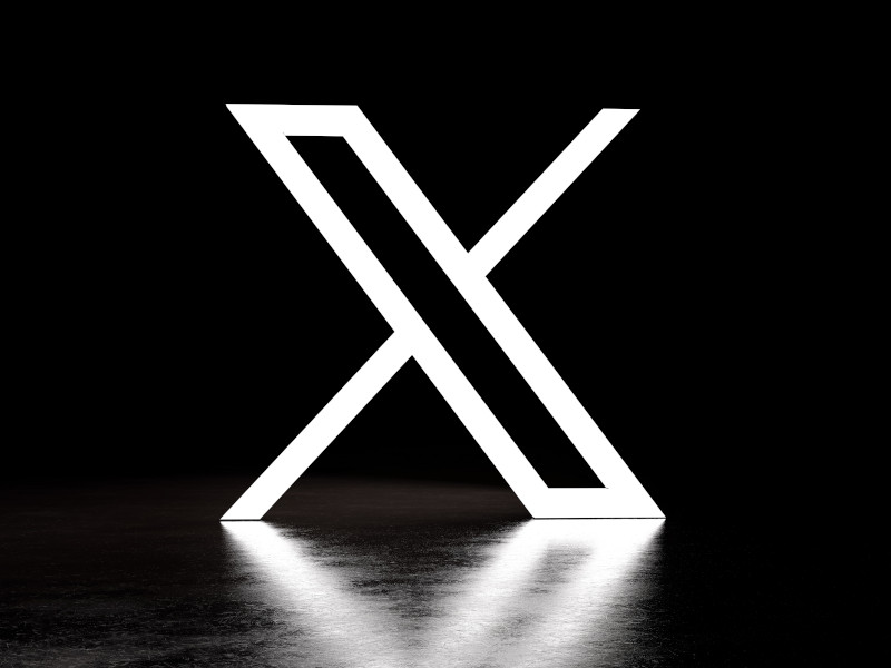 X logo in a black background.