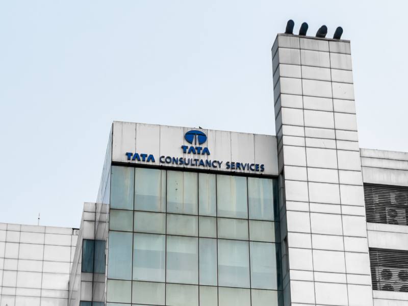 The Tata Consultancy Services or TCS logo on the side of a tall grey building.