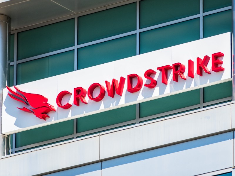 A close-up of a red 3D Crowdstrike logo on a white sign on a large building.