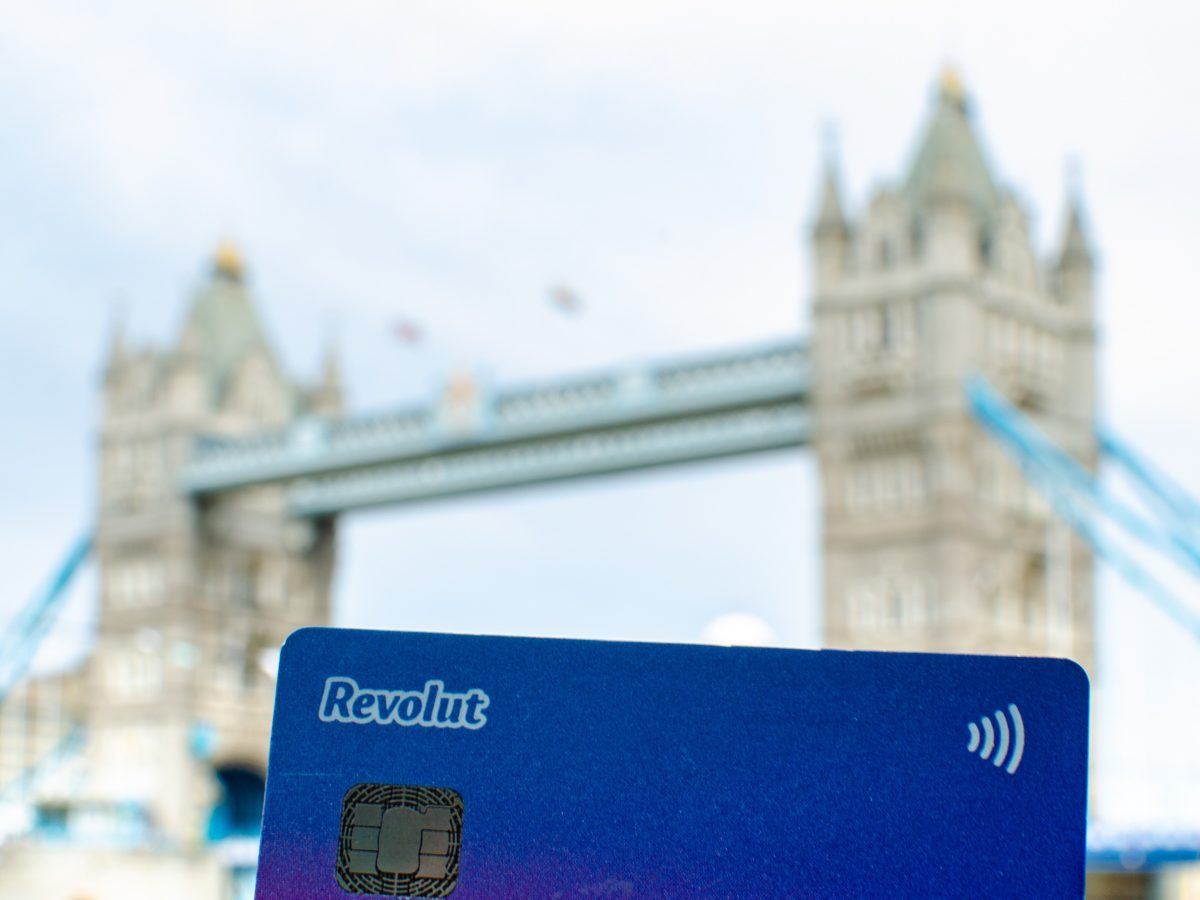 Photo of a Revolut debit card with the London Bridge in the background.