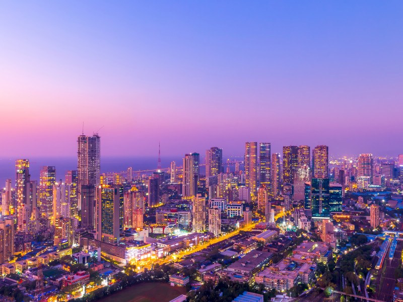 Skyline of Mumbai with many skyscrapers and the sea in the background.