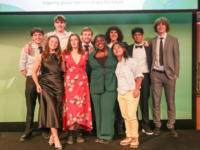 A group of 10 third-level students stand on stage, smiling at the camera.