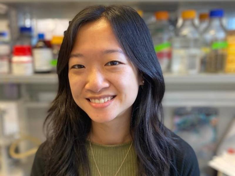 Doctor Josephine Wu standing in a lab with various mixtures behind her.