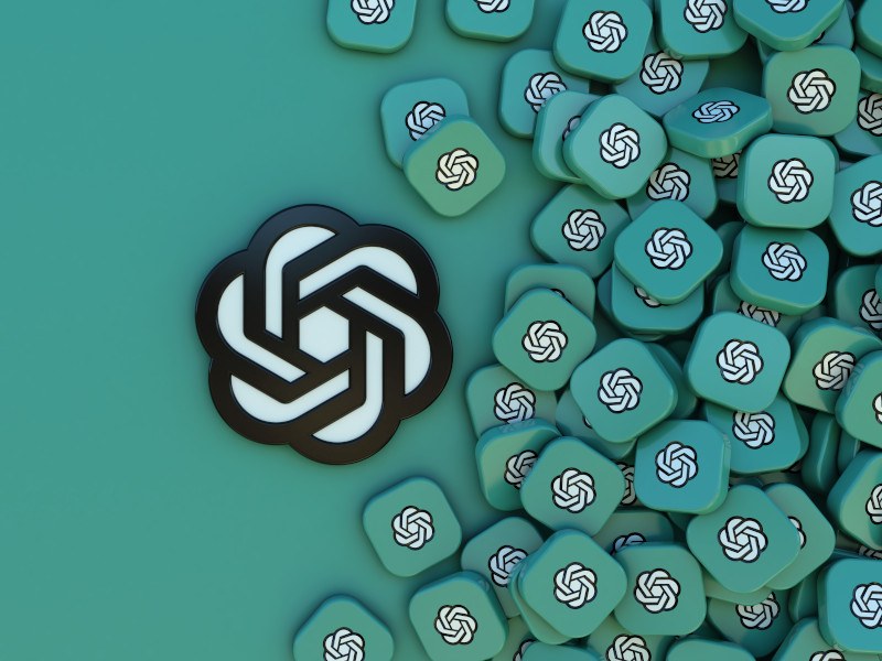 Illustration of OpenAI logo with small 3D blocks also bearing the logo to its right.