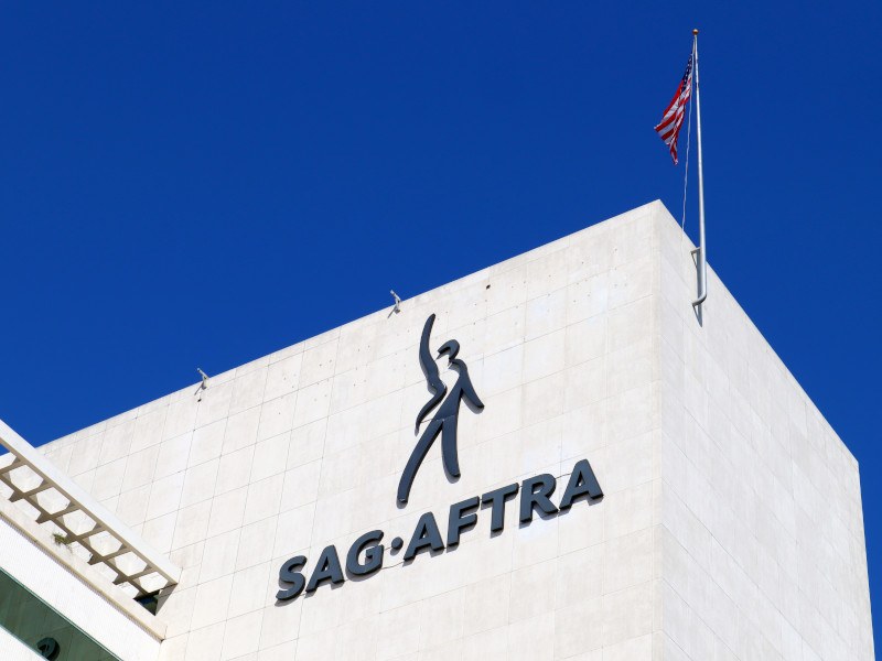 SAG-AFTRA logo on a building with a US flag.