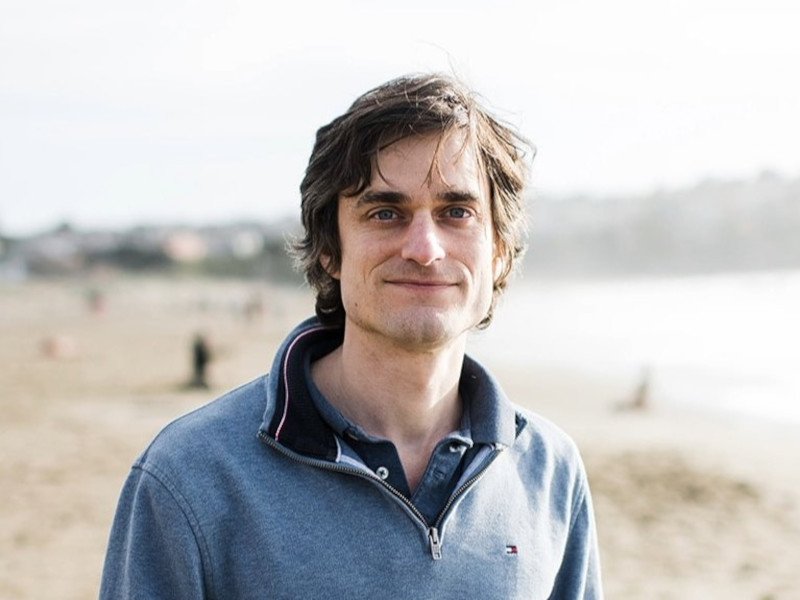 Headshot of John Schulman of OpenAI at a beach.