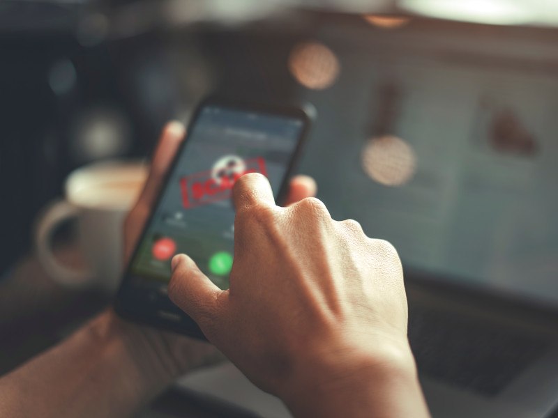 Close-up of a person using a smartphone with an unknown number calling.