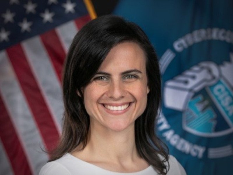 Headshot of Lisa Einstein smiling with the US flag in the background.