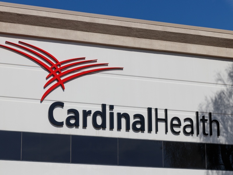 The Cardinal Health name and red logo on a white wall of a building,