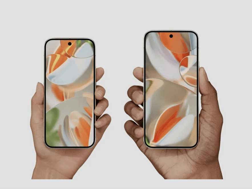 Two hands holding up Pixel 9 smartphones in a clear background.