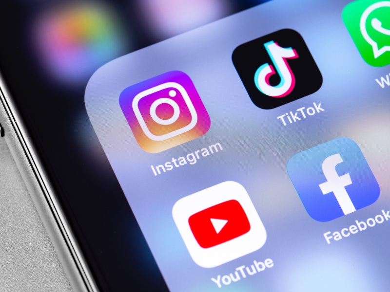 The logos of multiple apps such as Facebook, Instagram, YouTube and TikTok on a smartphone screen. Used for context of platforms being investigated under EU DSA rules.