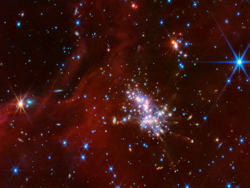 An image of various stars and gases of different colours, with a dense section full of stars near the centre of the image. Taken by the James Webb Space Telescope