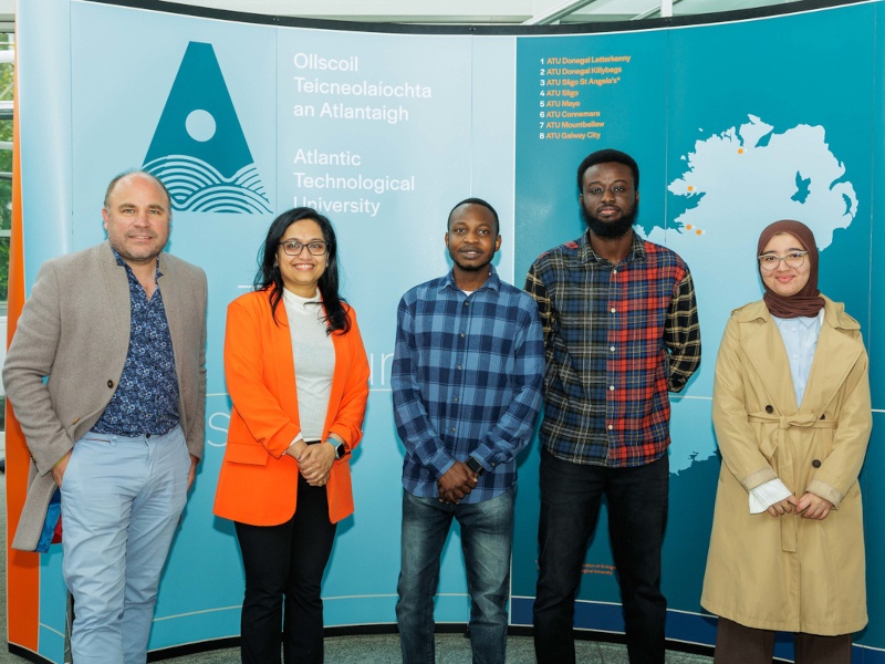 Two women and three men stand in front of a sign for ATU. They are the Bias Busters team of researchers.