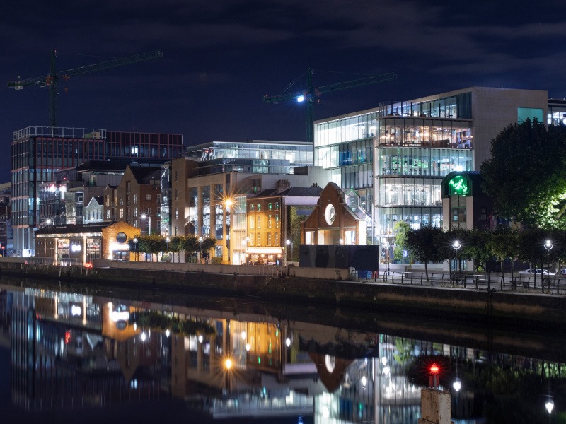 Skyline of the offices on the shoreline of the 'River Liffey' in Dublin illuminated at night.