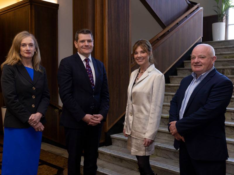 Four people standing in front of a flight of stairs. Two women and two men.