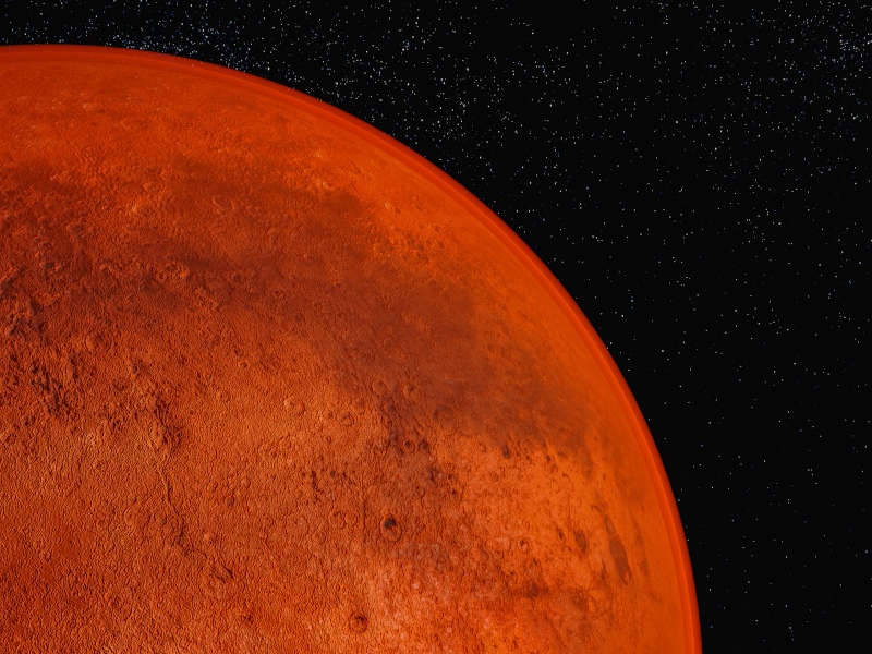 A quadrant of Mars coloured red on the foreground, pitch black space with stars in the back.