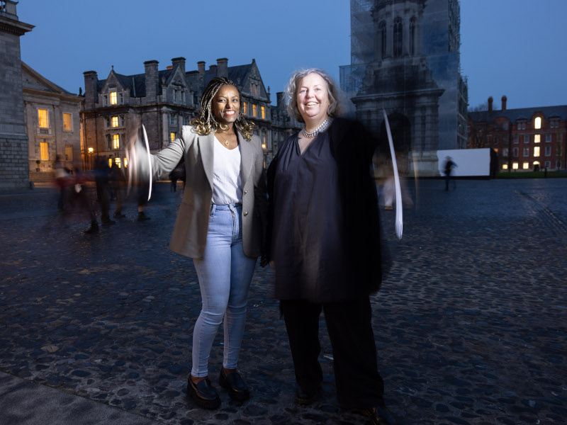 Two woman standing together at Trinity smiling.