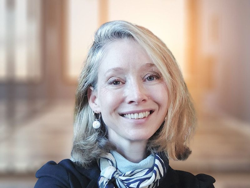 A close-up headshot of Dr April Hargreaves. She has short blonde hair and smiles at the camera.