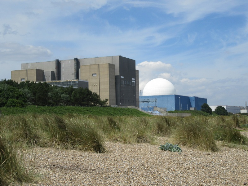 A nuclear power plant facility. It is located near a grassland. Some sand is also present in the area.