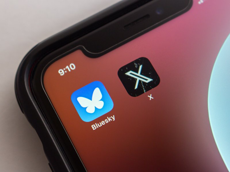 A smartphone screen showing the Bluesky app and the X app.