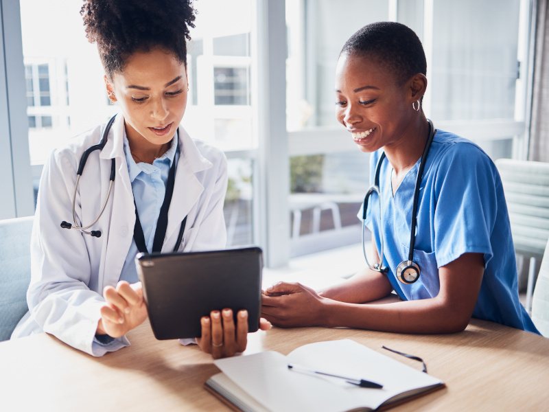 Two healthcare professionals looking at a tablet.