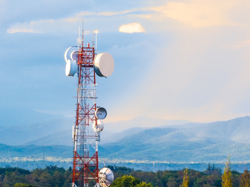 A telecommunications tower against a mountain landscape.