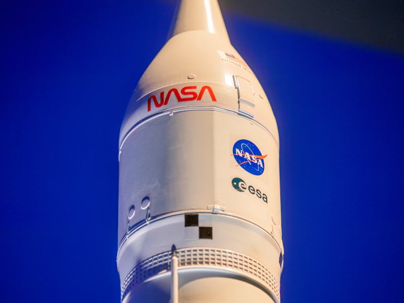 Blue background and a rocket with the NASA logo on it.