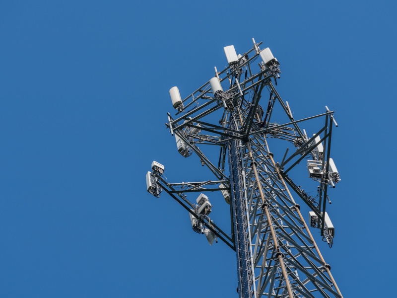 Blue sky in the back and a low angle shot of a telecom tower.