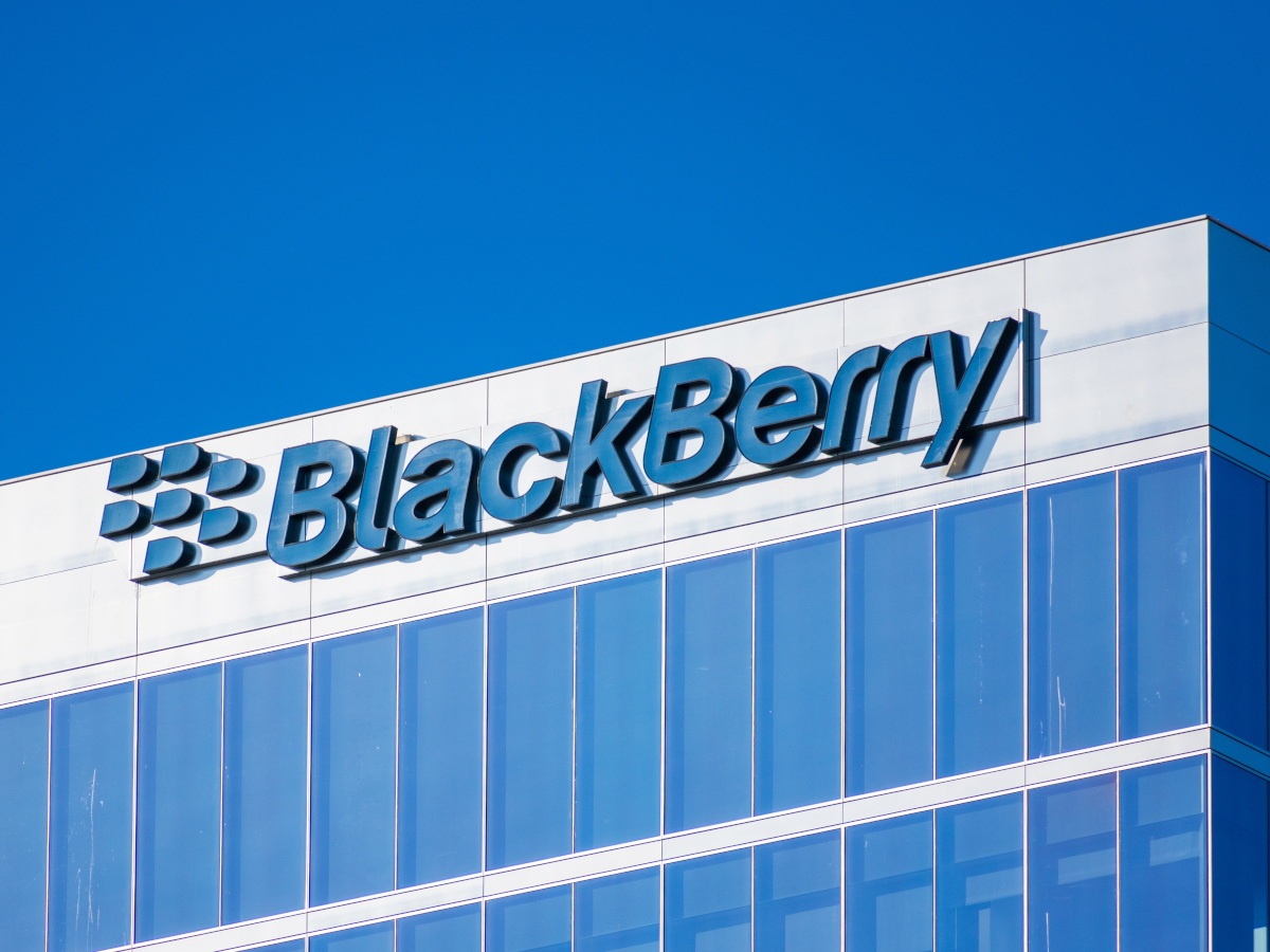 A large glass building against a bright blue sky. The top of the building has the BlackBerry logo on top.