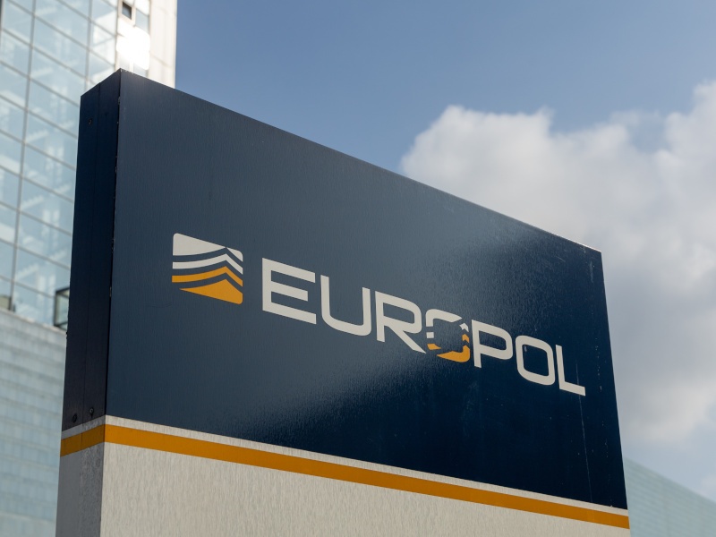 A close-up of a Europol sign outside a building on a bright day.