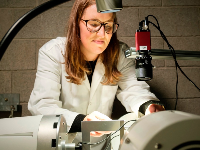 Aisling Ní Annaidh works in a lab in a white coat.