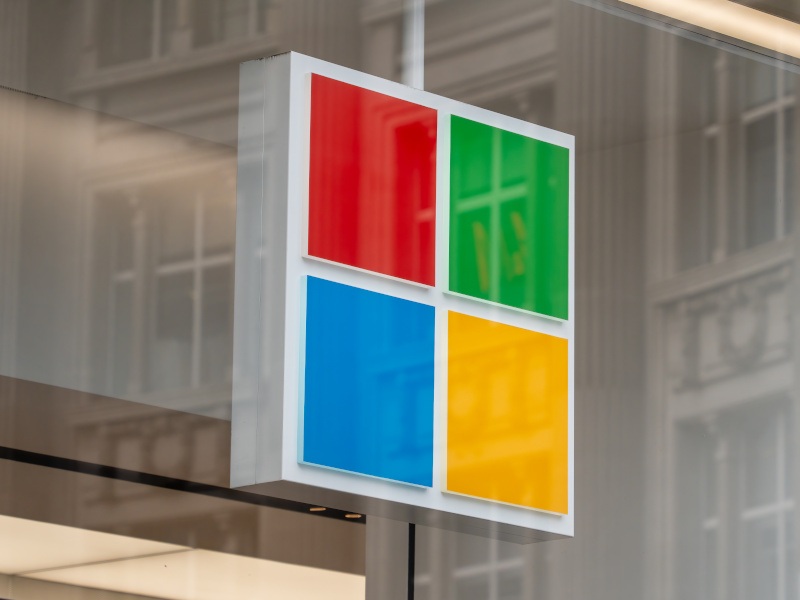 A close-up of the four-coloured squares of the Microsoft logo hanging in a shop window.