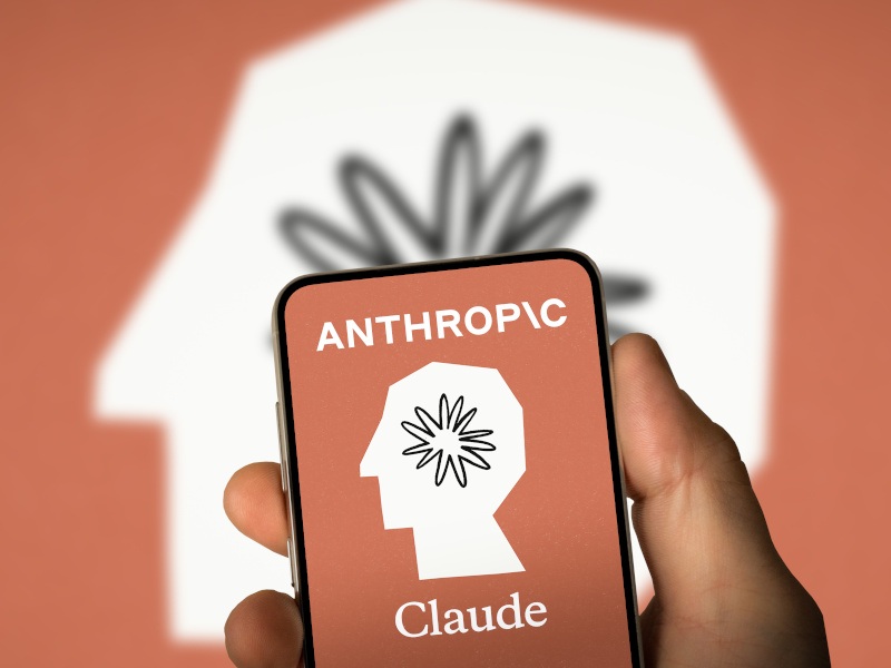 Anthropic logo in the background and foreground, on a smartphone.