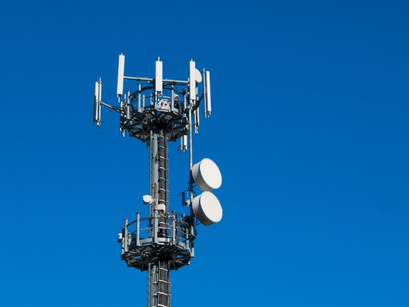 Communication tower against crystal clear blue sky background.