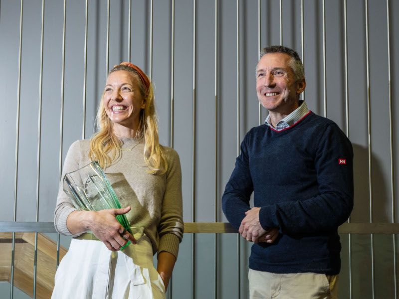 A woman and a man stand next to each other while smiling and looking off to the right of the camera. They are Donal O'Gorman and Heidi Davis, the founders of Peri.