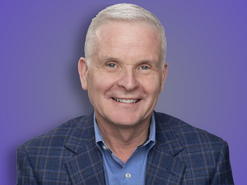 A close-up headshot of Donald McDonnell in a dark blue suit.